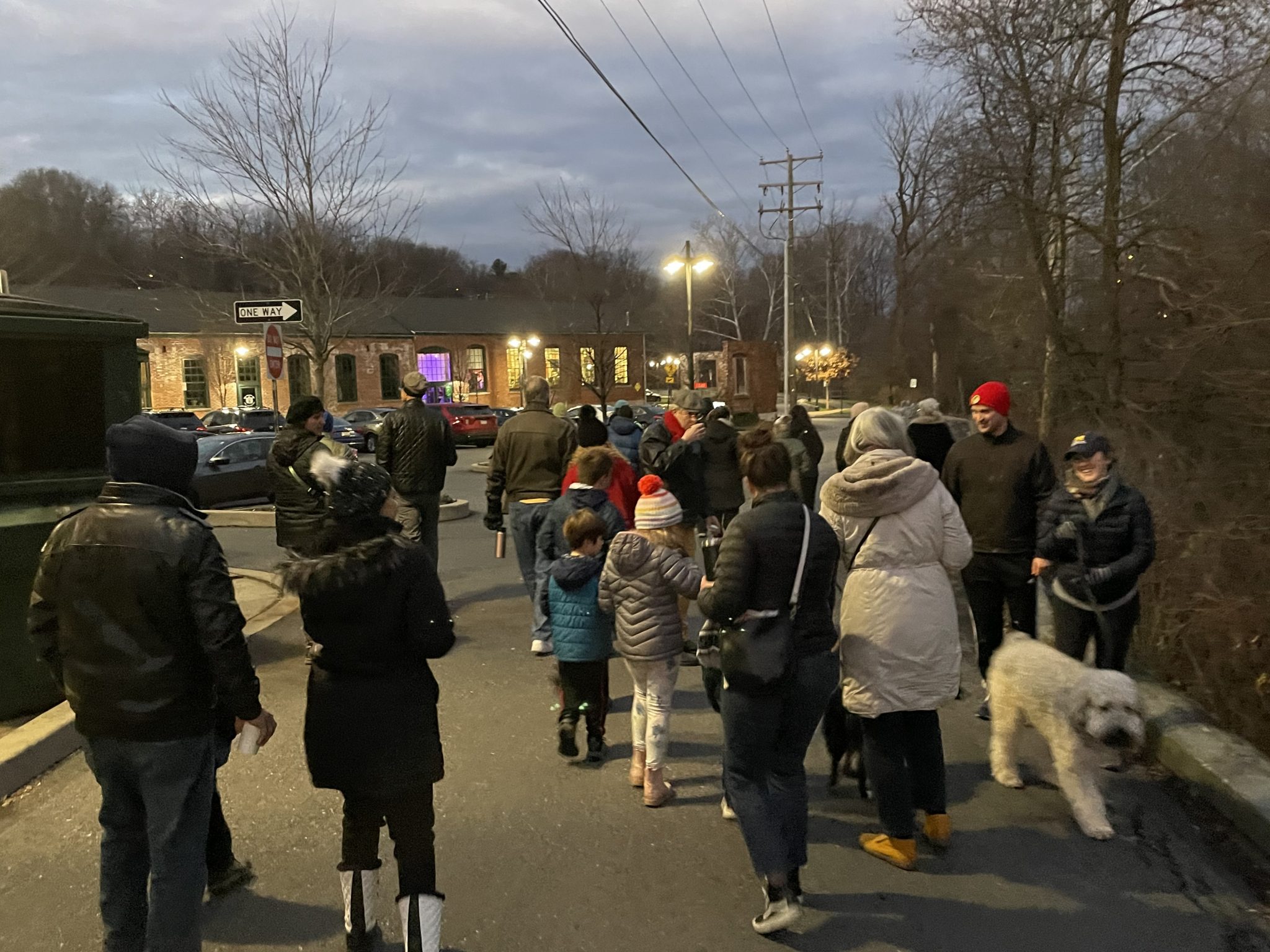 A group of people walk outside during the Winter Solstice event at the Karl Stirner Arts Trail.