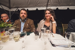People sit at tables under a tent at the Karl Stirner Arts Trail gala.