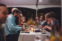 People sit at tables under a tent and eat at  the Karl Stirner Arts Trail gala.