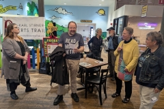 Darrell Parry reads one of his original poems aloud at Easton Public Market as people listen.