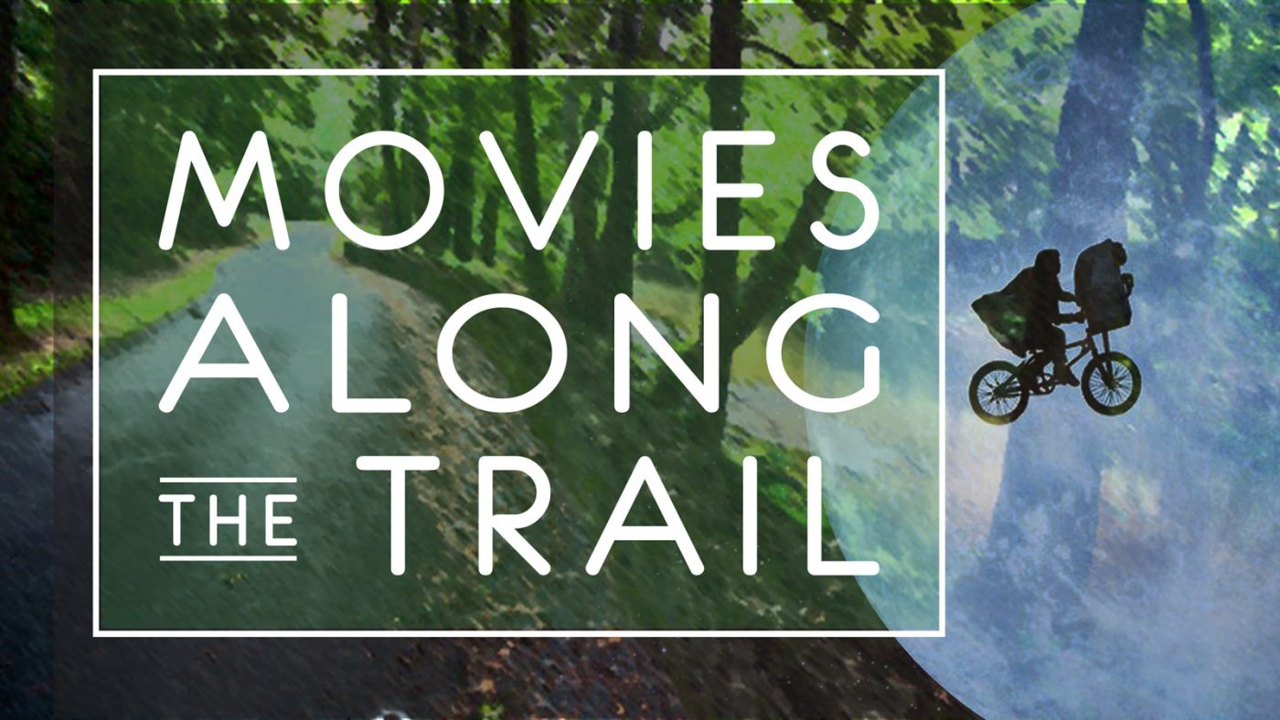 A Movies Along the Trail poster with an image of the iconic scene from the film ET with a child and the creature flying on a bike
