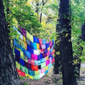 Colorful fabric hangs between trees in the artwork Sight Lines by Oklahoma artist Rachel Hayes on the Karl Stirner Arts Trail in Easton, Pennsylvania.