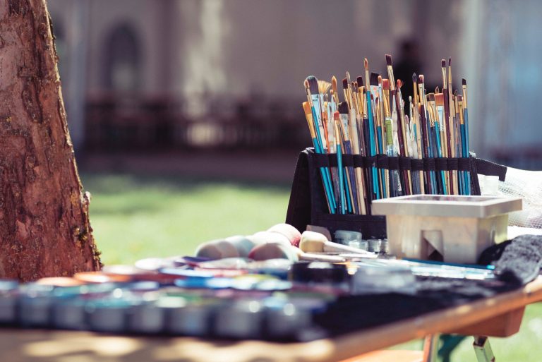 A group of paint brushes and paints on a table