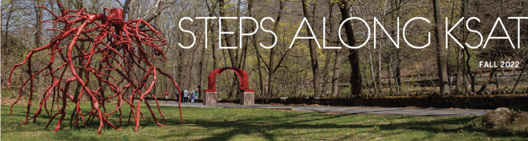 A sculpture with red tree roots and the red arch sculpture on the Karl Stirner Arts Trail in Easton, Pennsylvania