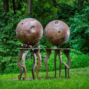 Nitrogen and Hydrogen by David Kimball Anderson, two metal sculptures in the shape of balls standing on metal pedestals, on the Karl Stirner Arts Trail in Easton, Pennsylvania