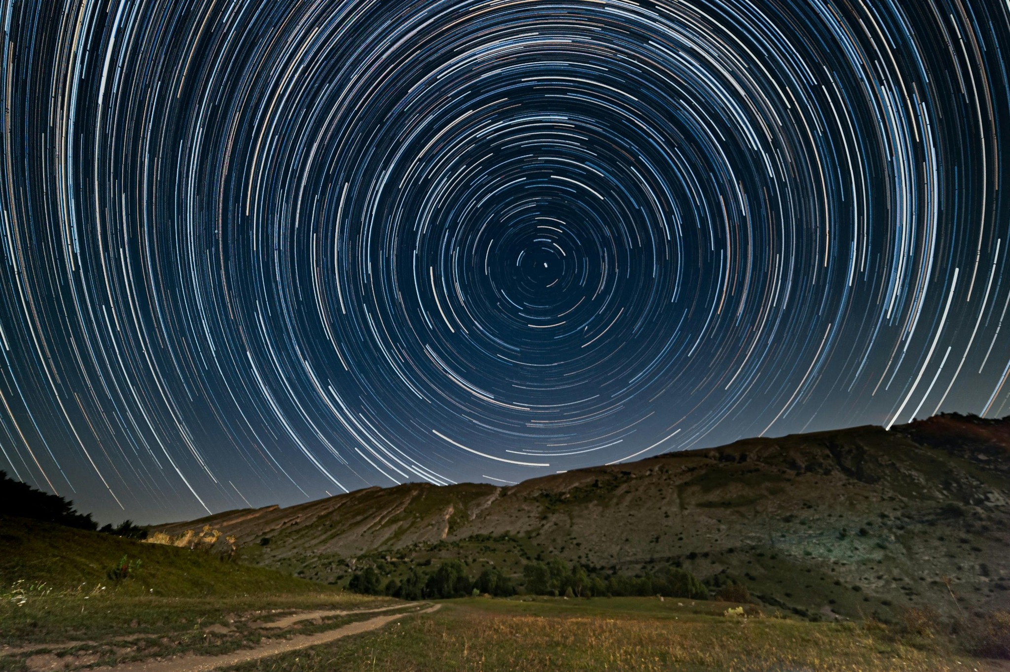 A dark blue sky with many white circles within circles
