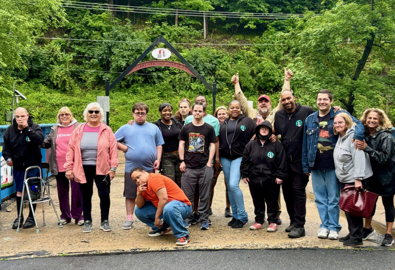 Developmentally and intellectually challenged adults, Rotary and Kiwanis volunteers, and Danny Moyer pose for a group shot at the Young Masters Wall on the Karl Stirner Arts Trail in Easton, Pennsylvania.