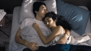 A couple lay asleep in bed together in a scene from the movie Paterson starring Adam Driver