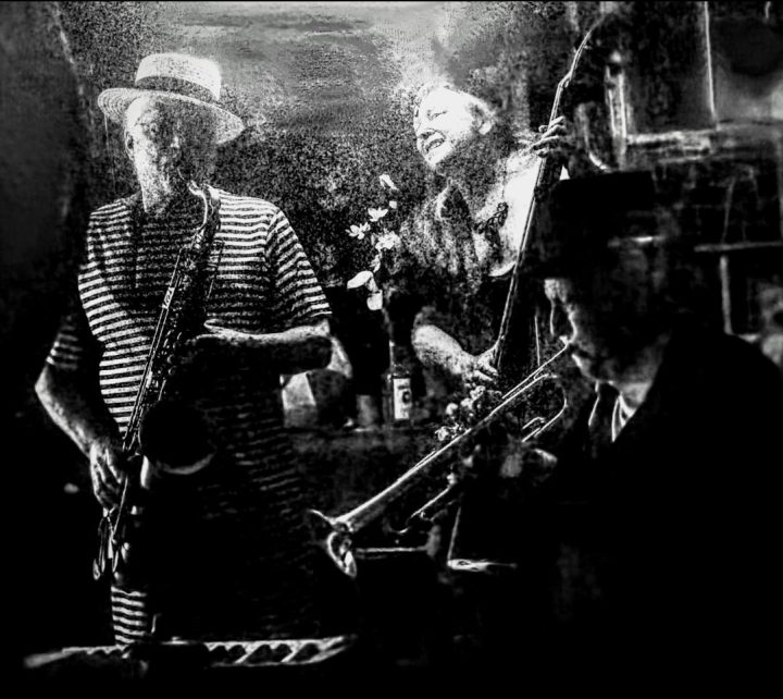 A black and white photo of a saxophone player, bass player, and trumpet player in concert